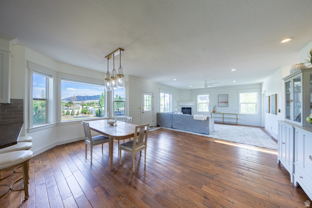 868 Braddock Lane Alpine, UT 84004 - Photo 19 of 64 Open-concept living area featuring wood-finish flooring, a dining space with a multi-light pendant fixture, and a bay window