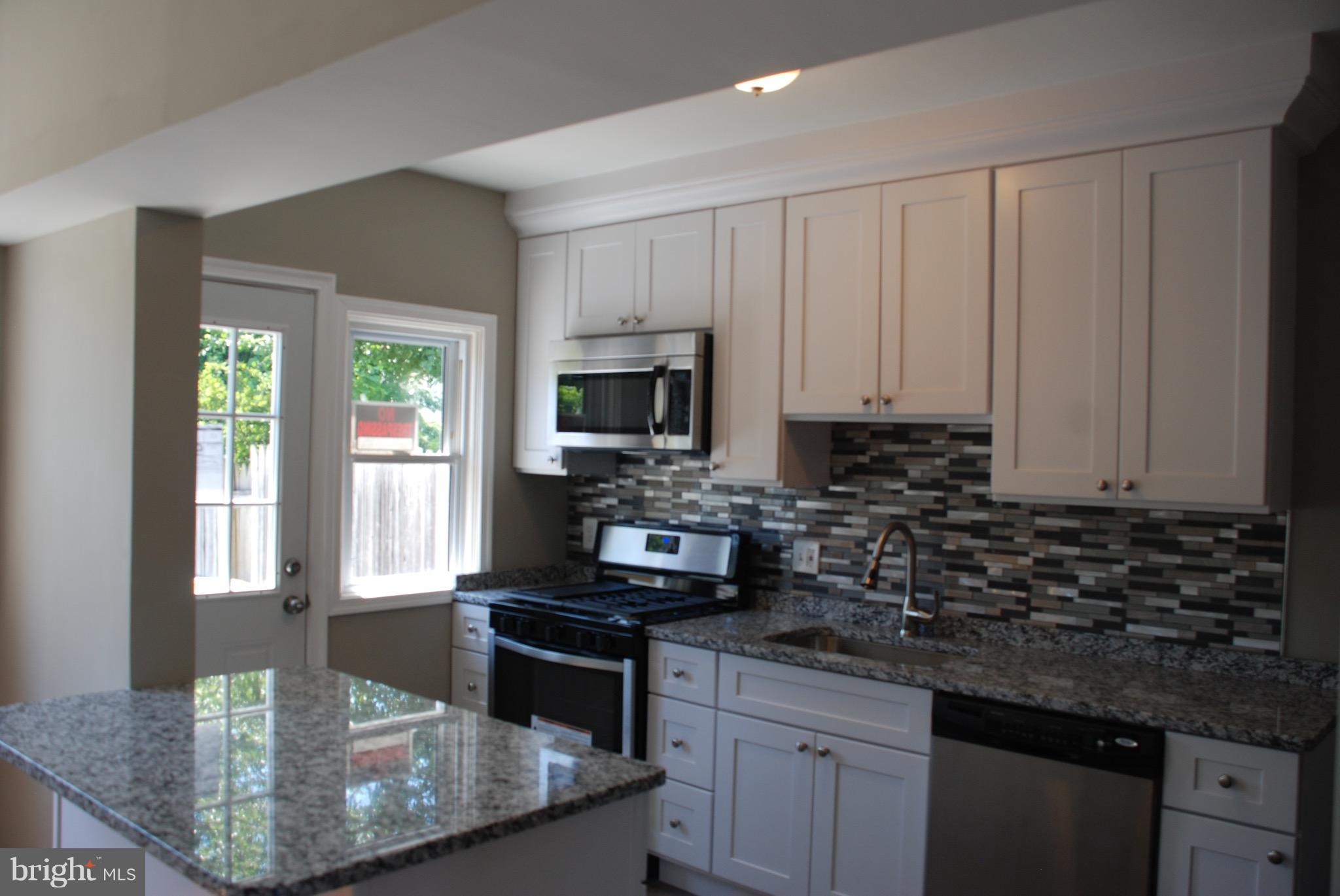 139 West Meadow Road Baltimore, MD 21225 - Photo 2 of 11 a kitchen with stainless steel appliances granite countertop a sink a stove and cabinets