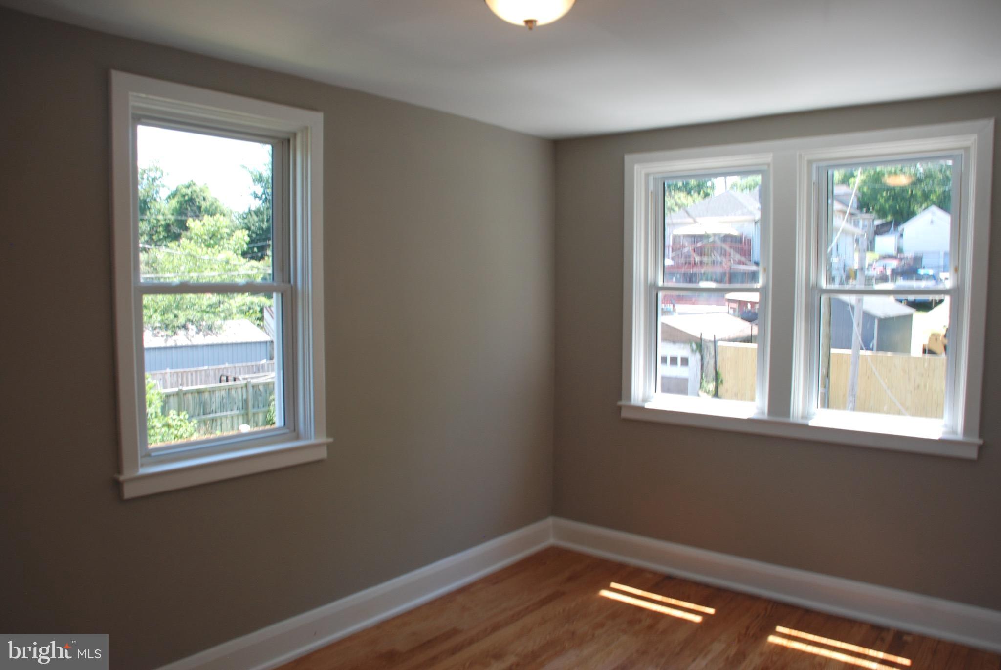 139 West Meadow Road Baltimore, MD 21225 - Photo 6 of 11 a view of empty room with wooden floor and windows