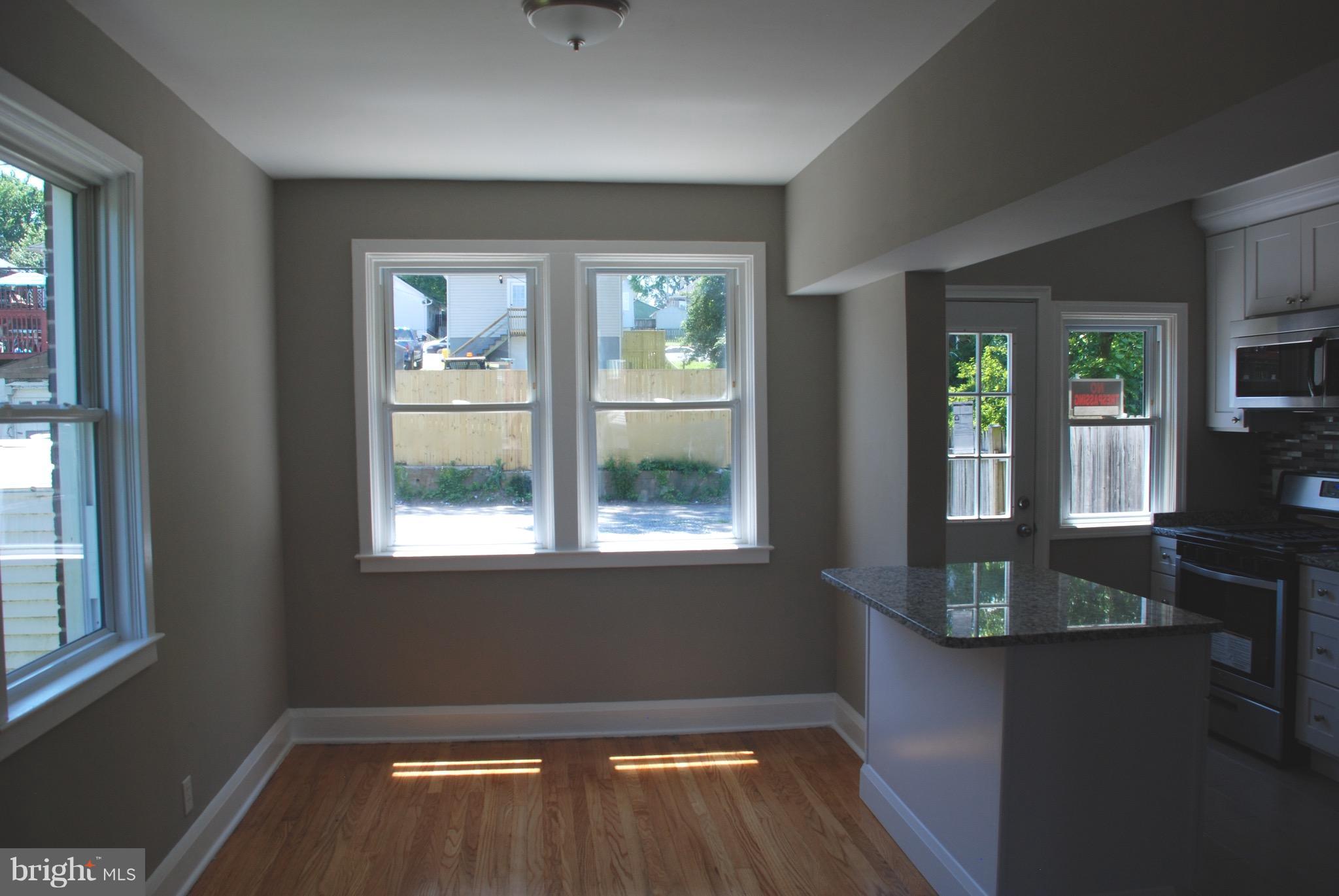 139 West Meadow Road Baltimore, MD 21225 - Photo 8 of 11 an empty room with wooden floor and windows