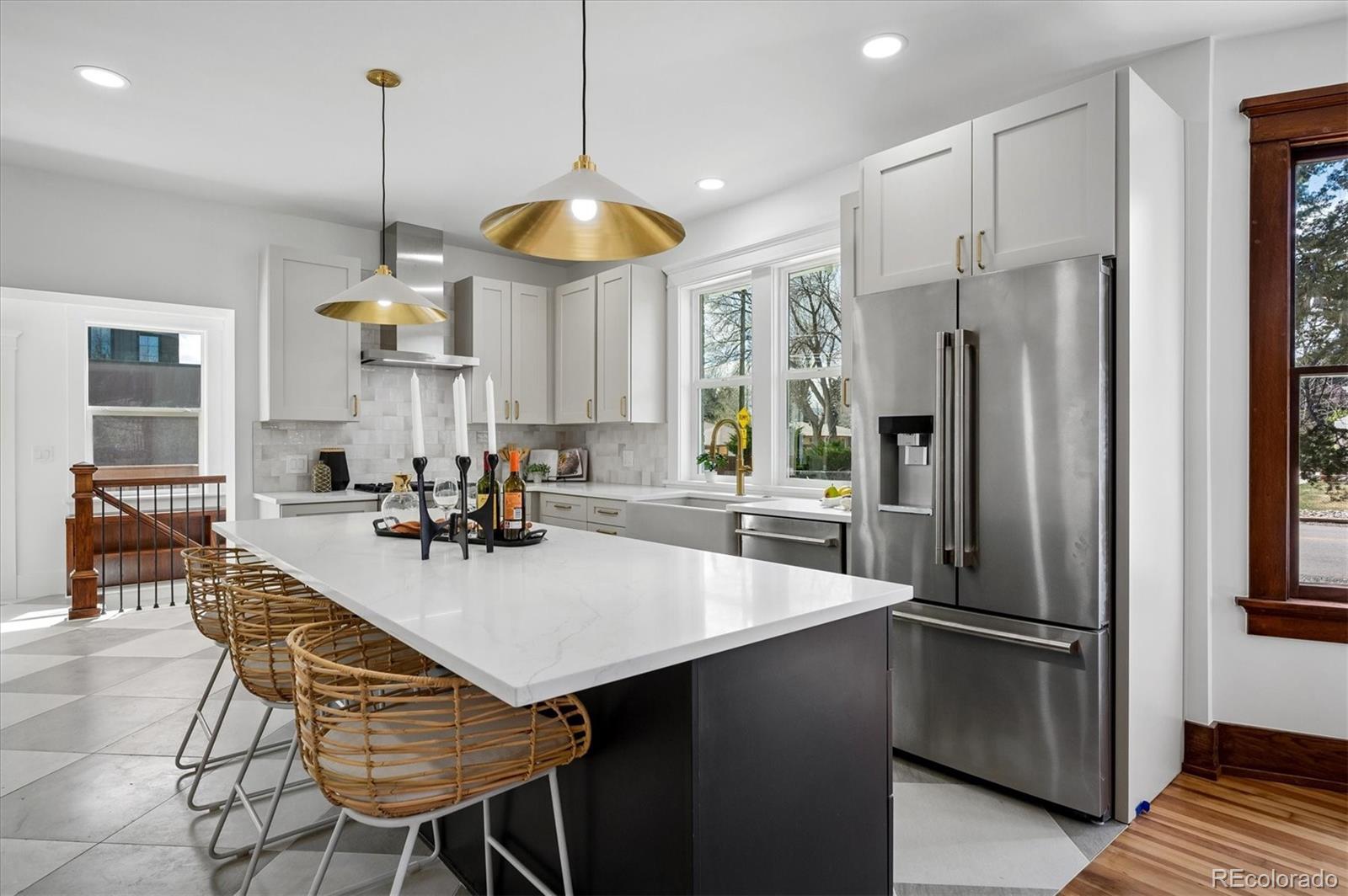 7198 West 29th Avenue Wheat Ridge, CO 80033 - Photo 9 of 49 a kitchen with stainless steel appliances granite countertop a refrigerator a sink a stove a dining table and chairs