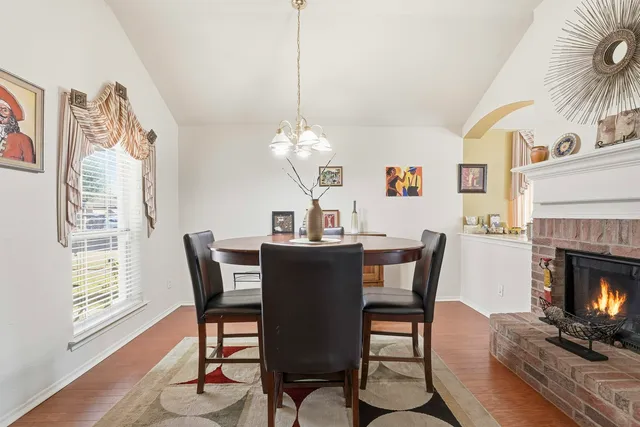 a dining room with furniture a fireplace and wooden floor