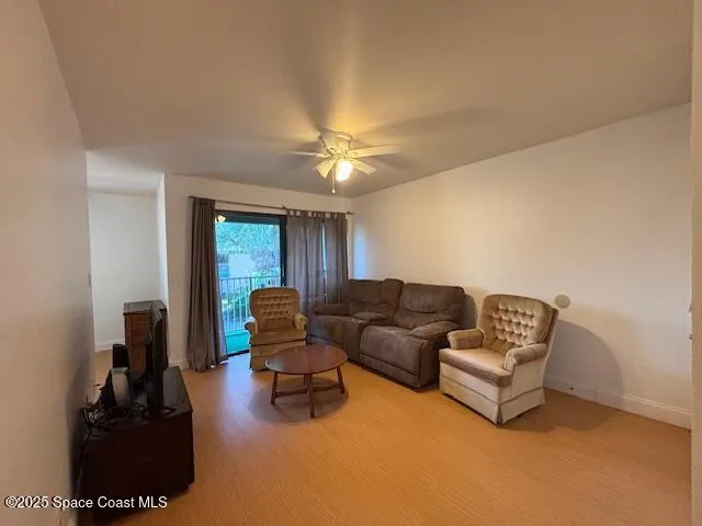 a living room with furniture and a ceiling fan