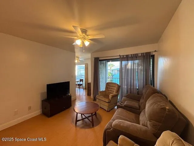 a living room with furniture a ceiling fan and a flat screen tv