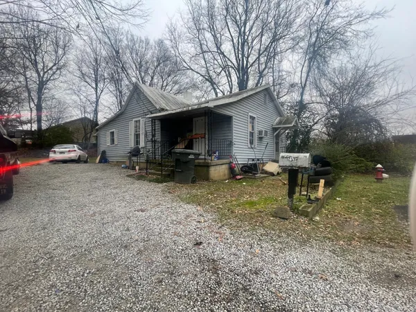 a backyard of a house with barbeque oven table and chairs