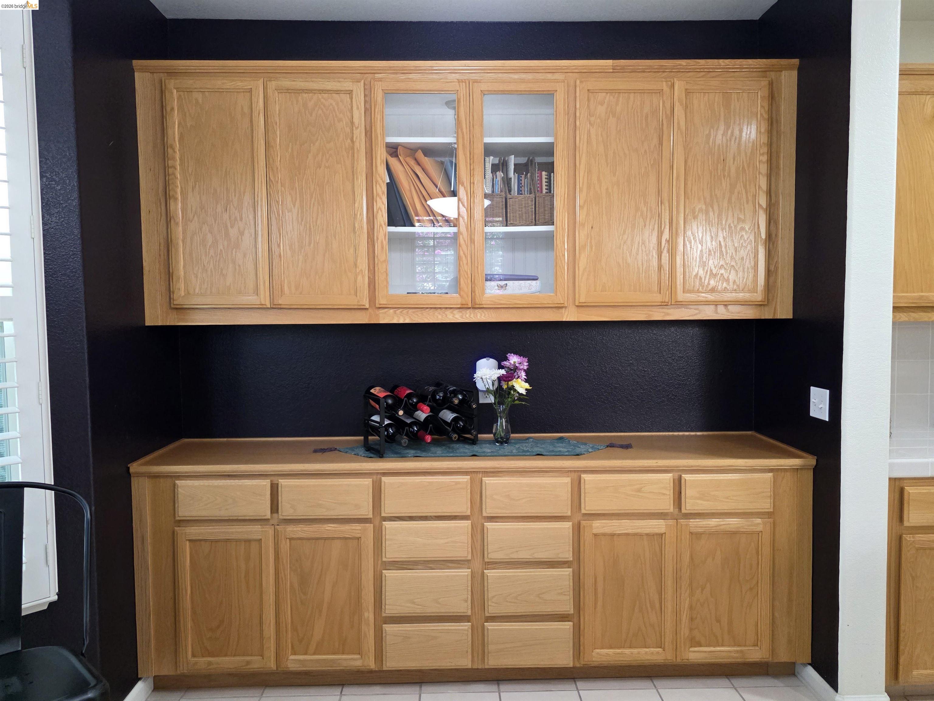 2607 Glow Road Riverbank, CA 95367 - Photo 21 of 42 Wood-finish cabinetry with glass-front display cabinets and a solid surface countertop