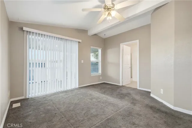 an empty room with fan and windows
