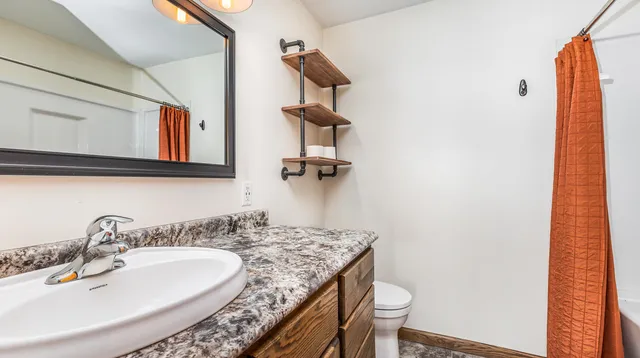 a bathroom with a granite countertop sink and a mirror