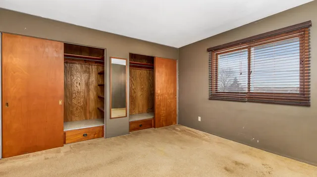 a view of an empty room with window and closet