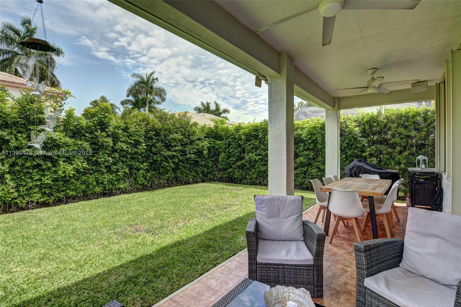 471 Fishtail Terrace Weston, FL 33327 - Photo 27 of 33 a view of a patio with table and chairs potted plants with floor to ceiling window