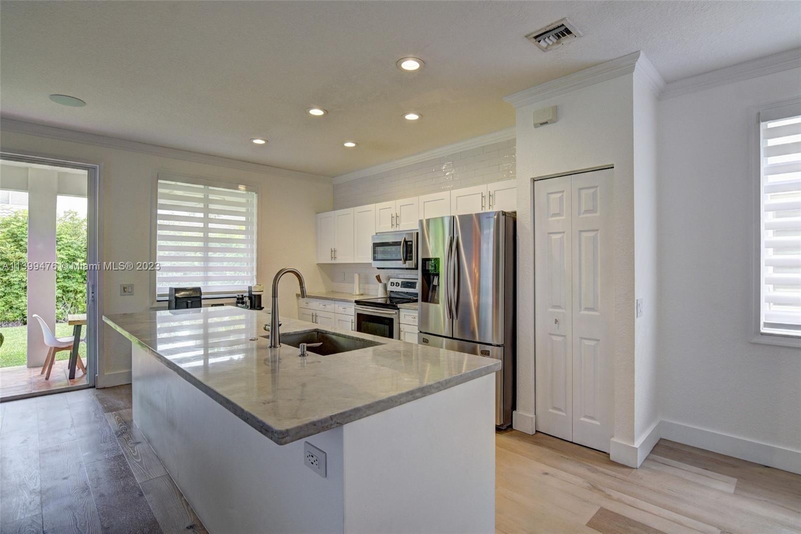 471 Fishtail Terrace Weston, FL 33327 - Photo 9 of 33 a kitchen with stainless steel appliances granite countertop a sink a stove and a refrigerator