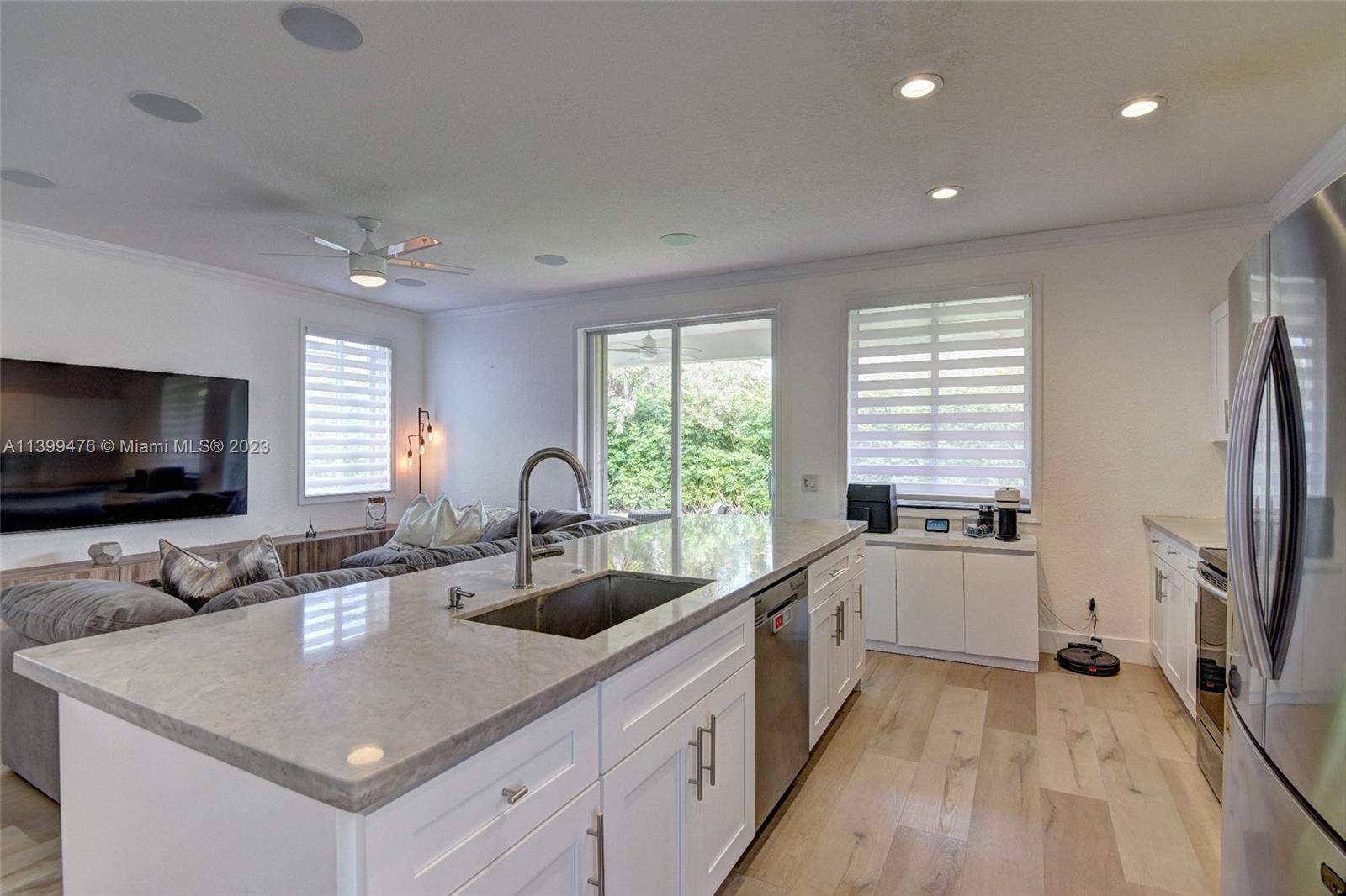 471 Fishtail Terrace Weston, FL 33327 - Photo 10 of 33 a kitchen with stainless steel appliances a sink a stove and a flat screen tv