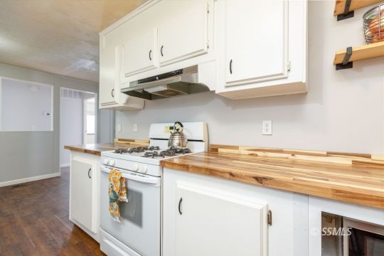 1015 South Mahan Street Ridgecrest, CA 93555 - Photo 12 of 31 a kitchen with stainless steel appliances granite countertop a sink and a stove