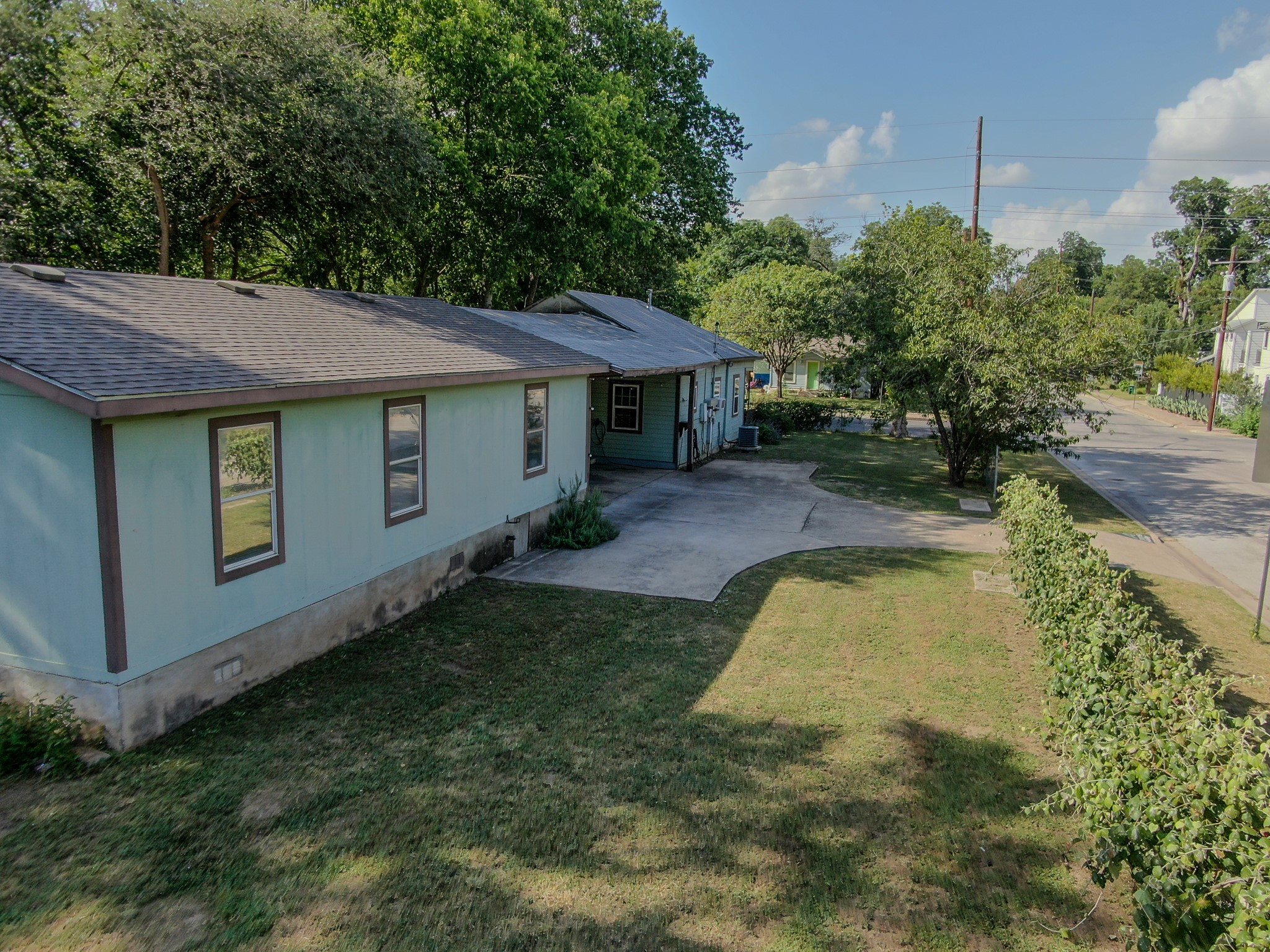 2015 Holly Street Austin, TX 78702 - Photo 23 of 24 A classic composition shingle roof crowns this welcoming residential property, bordered by mature trees.