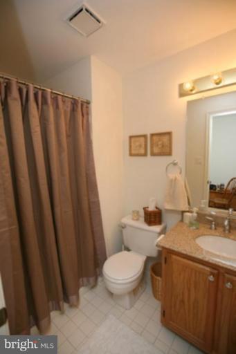 3323 Sea Port Way Silver Spring, MD 20902 - Photo 15 of 29 a bathroom with a sink a toilet a mirror and shower curtain