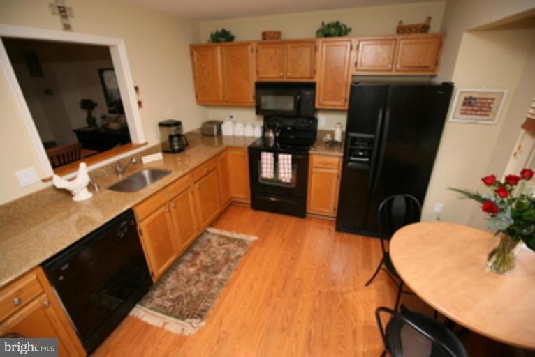 3323 Sea Port Way Silver Spring, MD 20902 - Photo 4 of 29 a kitchen with stainless steel appliances a stove refrigerator sink and microwave
