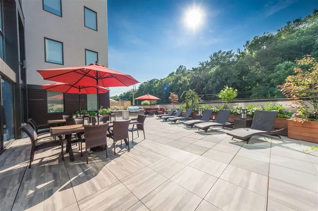 a view of the patio with dining table and chairs under an umbrella