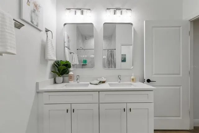a bathroom with double sink and a mirror
