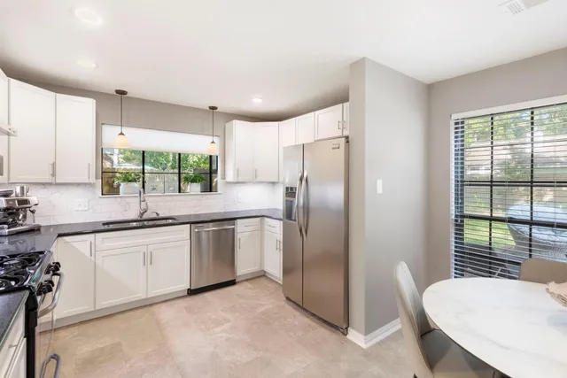 a kitchen with granite countertop a refrigerator and a sink
