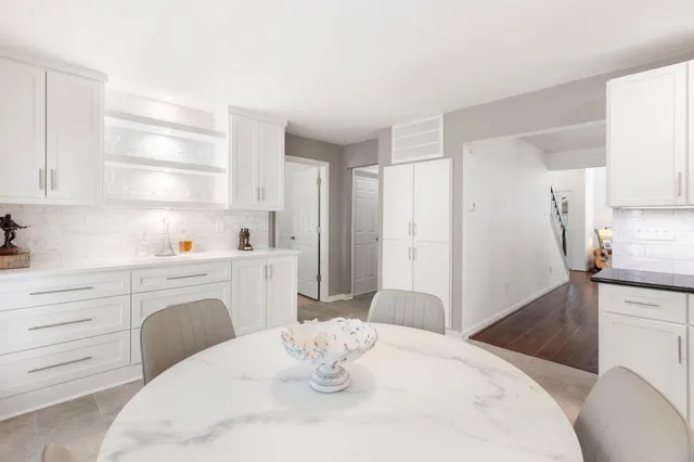 a kitchen with a white stove refrigerator and white cabinets