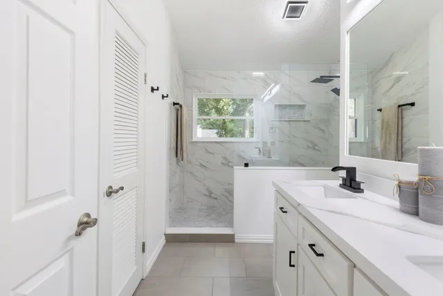 a bathroom with a sink a mirror and a shower