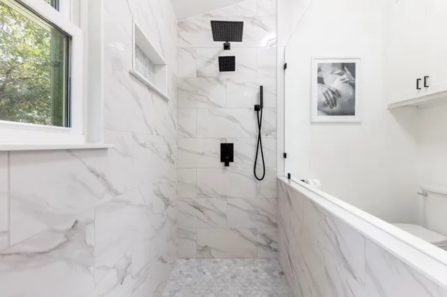 a bathroom with a bathtub sink and mirror