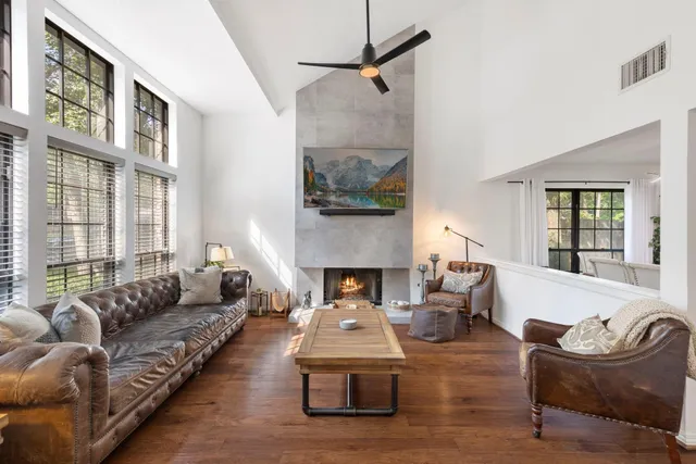 a living room with furniture fireplace and a large window