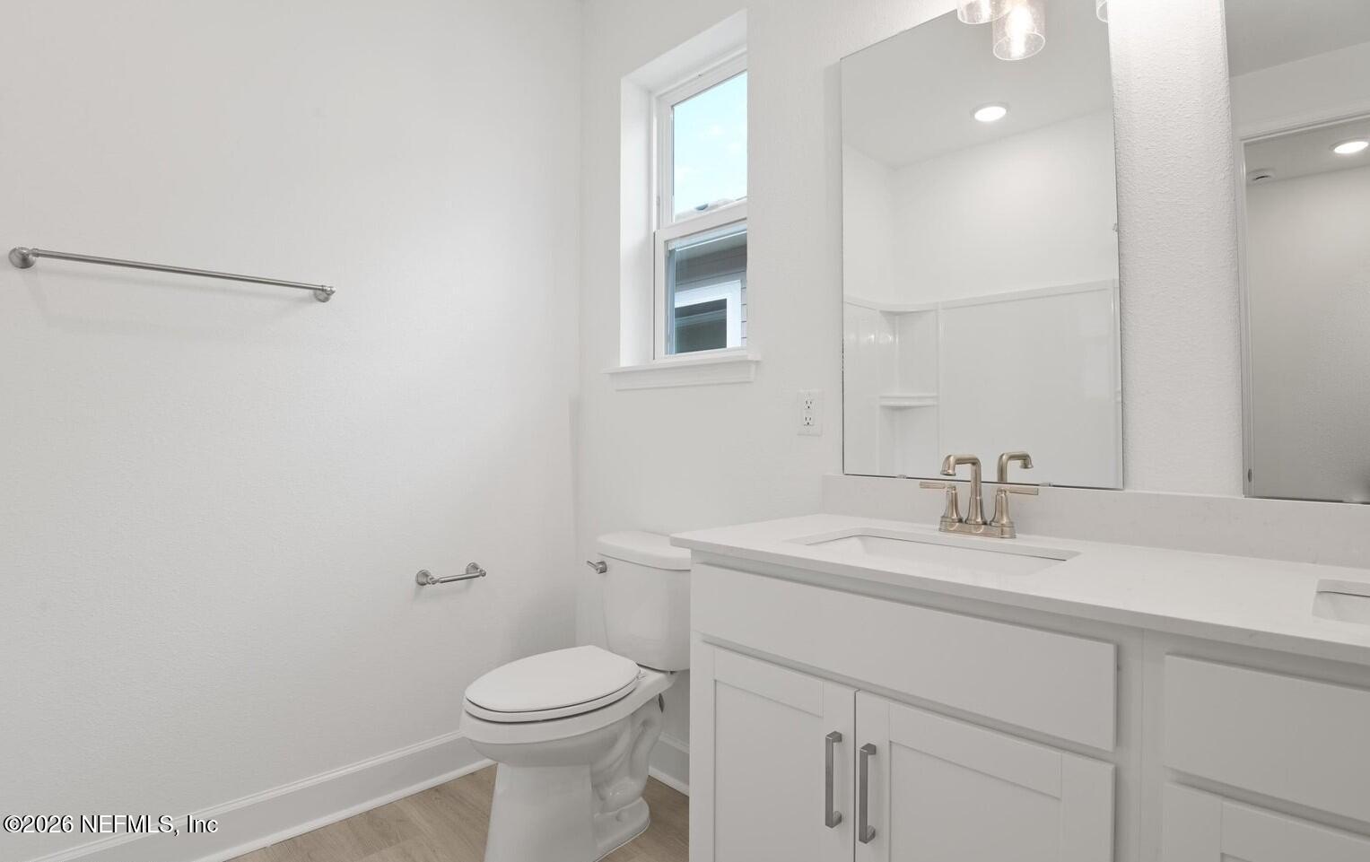434 Cedar Elm Way St. Augustine, FL 32092 - Photo 12 of 27 a bathroom with a toilet sink vanity and mirror