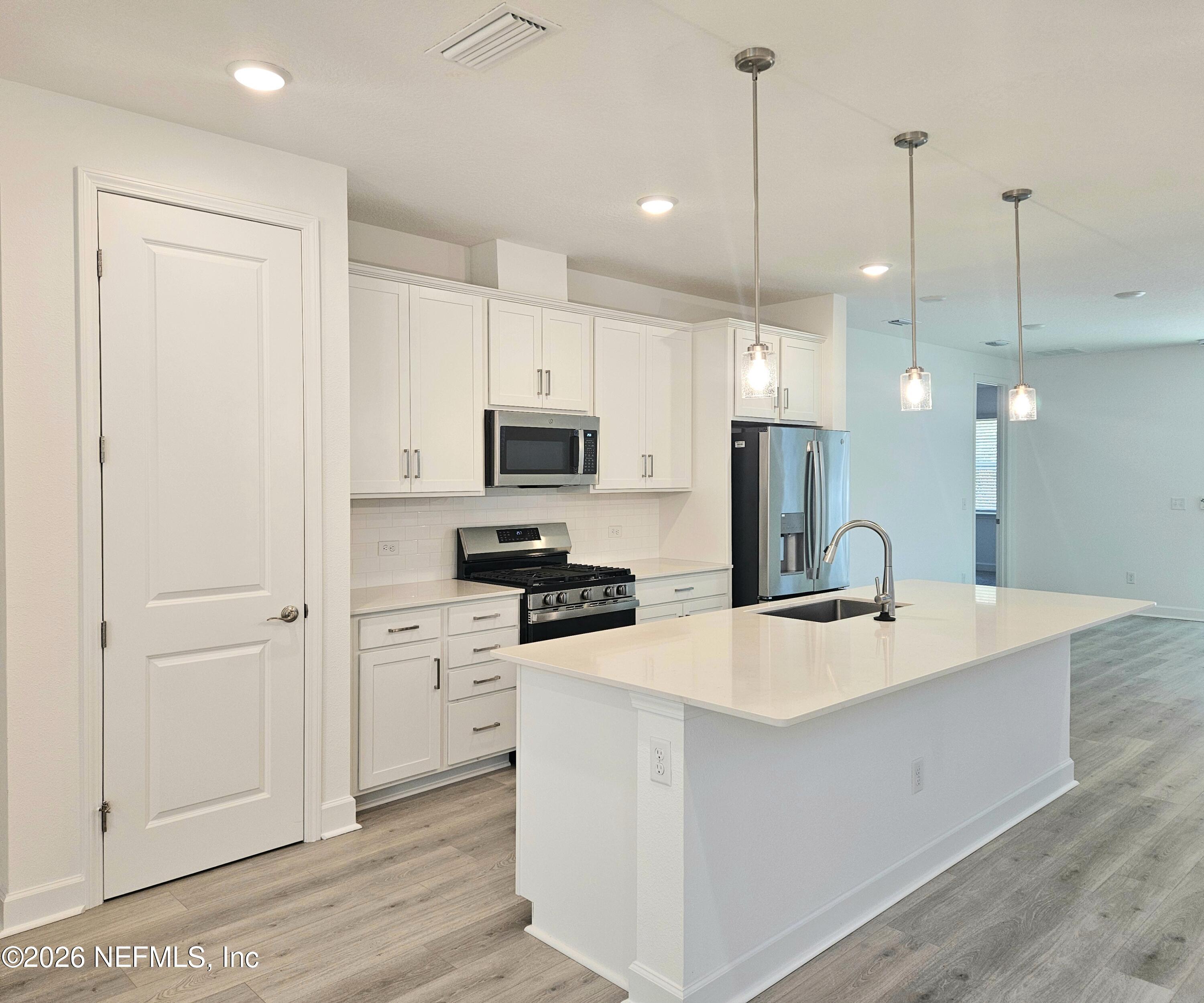 434 Cedar Elm Way St. Augustine, FL 32092 - Photo 4 of 27 a kitchen with stainless steel appliances kitchen island a white cabinets and refrigerator