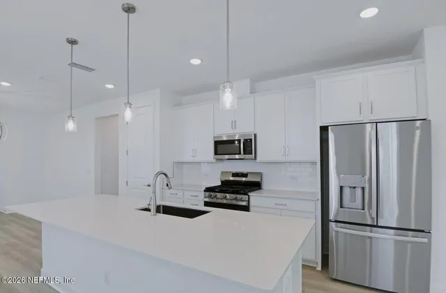 a kitchen with stainless steel appliances a refrigerator sink and microwave