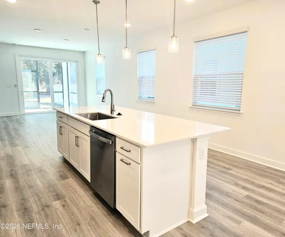 a view of a kitchen with refrigerator stove and wooden floor