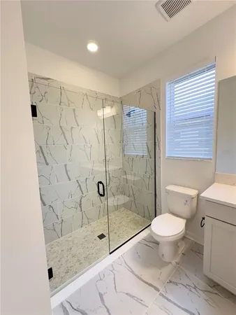 a bathroom with a granite countertop sink toilet and shower
