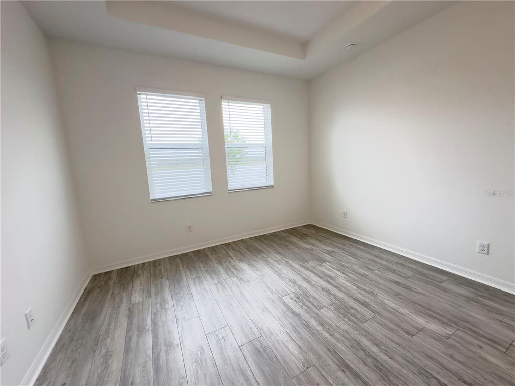 17937 Cherished Loop Lakewood Ranch, FL 34211 - Photo 16 of 30 an empty room with wooden floor and windows