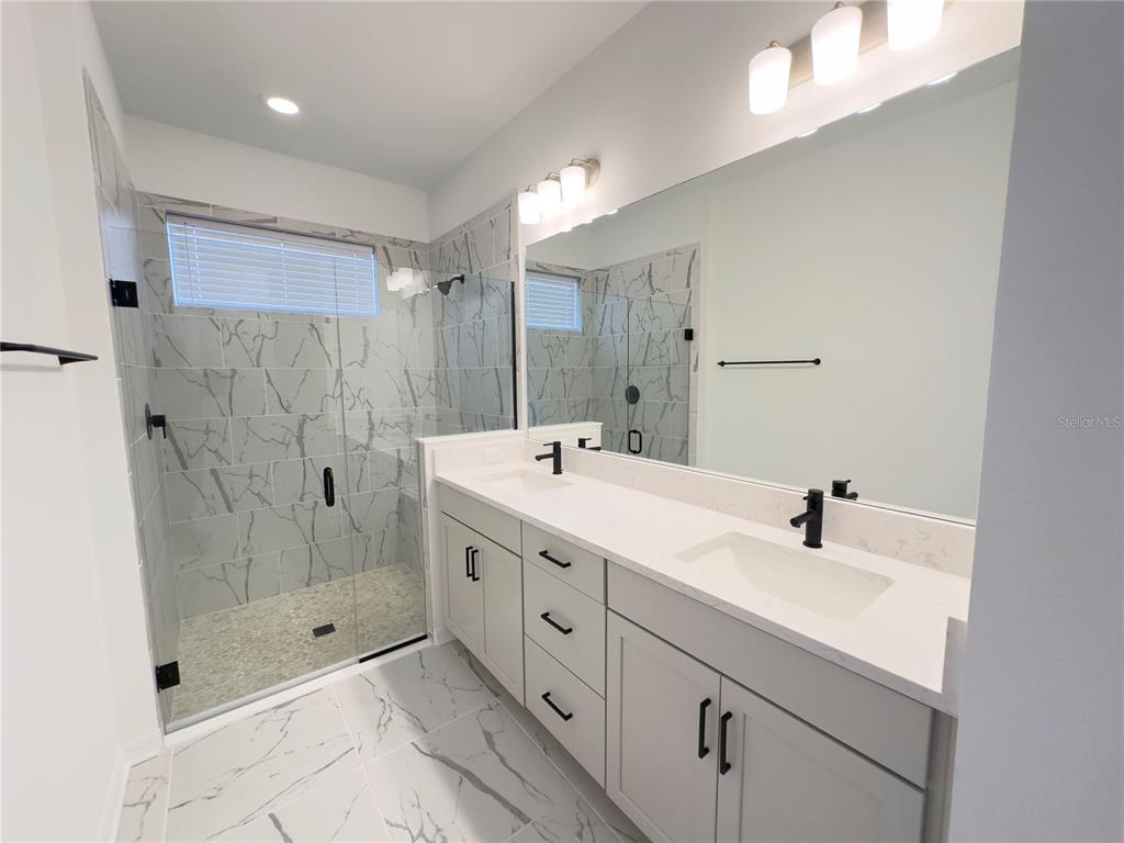 17937 Cherished Loop Lakewood Ranch, FL 34211 - Photo 19 of 30 a spacious bathroom with double sink shower and a mirror