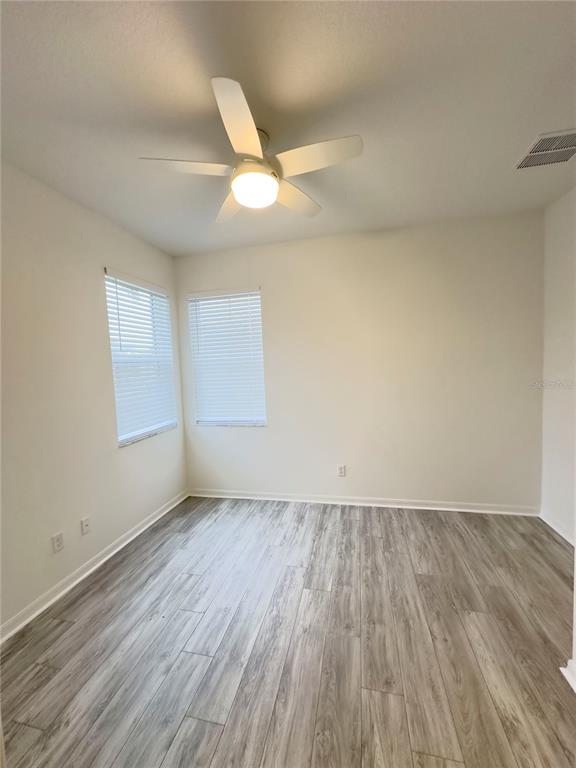 17937 Cherished Loop Lakewood Ranch, FL 34211 - Photo 9 of 30 an empty room with wooden floor and windows