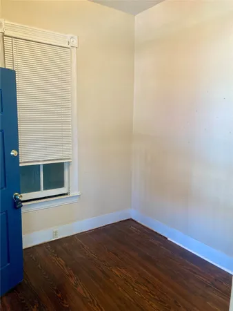 a view of a small space with wooden floor and a window