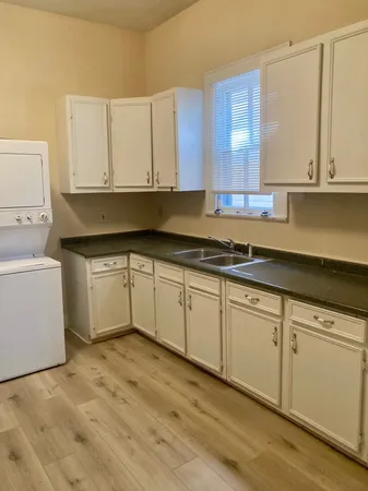 a kitchen with granite countertop white cabinets and white appliances