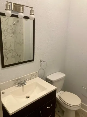 a bathroom with a toilet sink and mirror