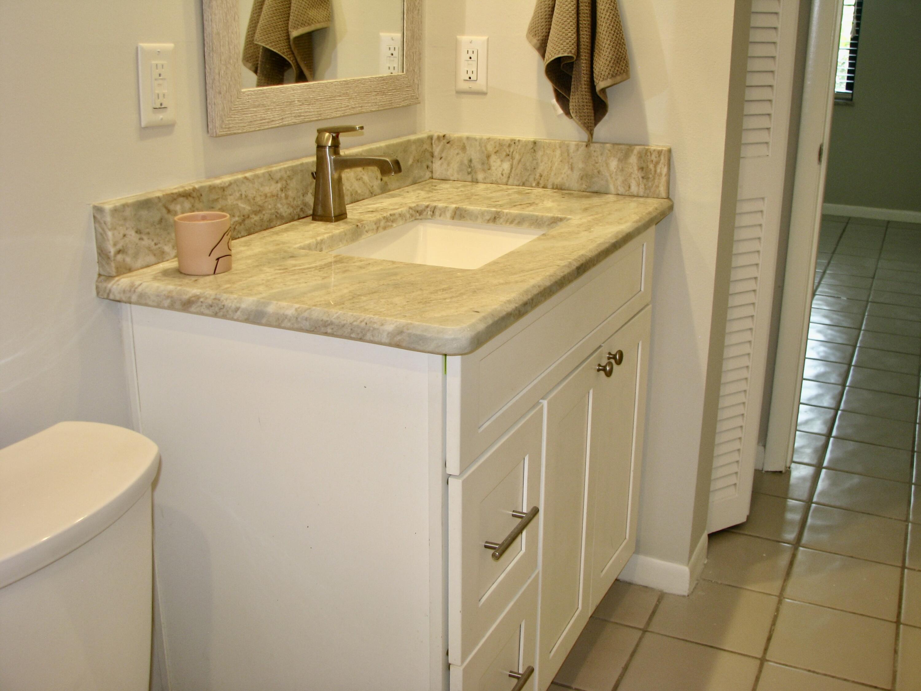 950 South Kanner Highway, Unit D4 Stuart, FL 34994 - Photo 14 of 36 a bathroom with a granite countertop sink and a mirror