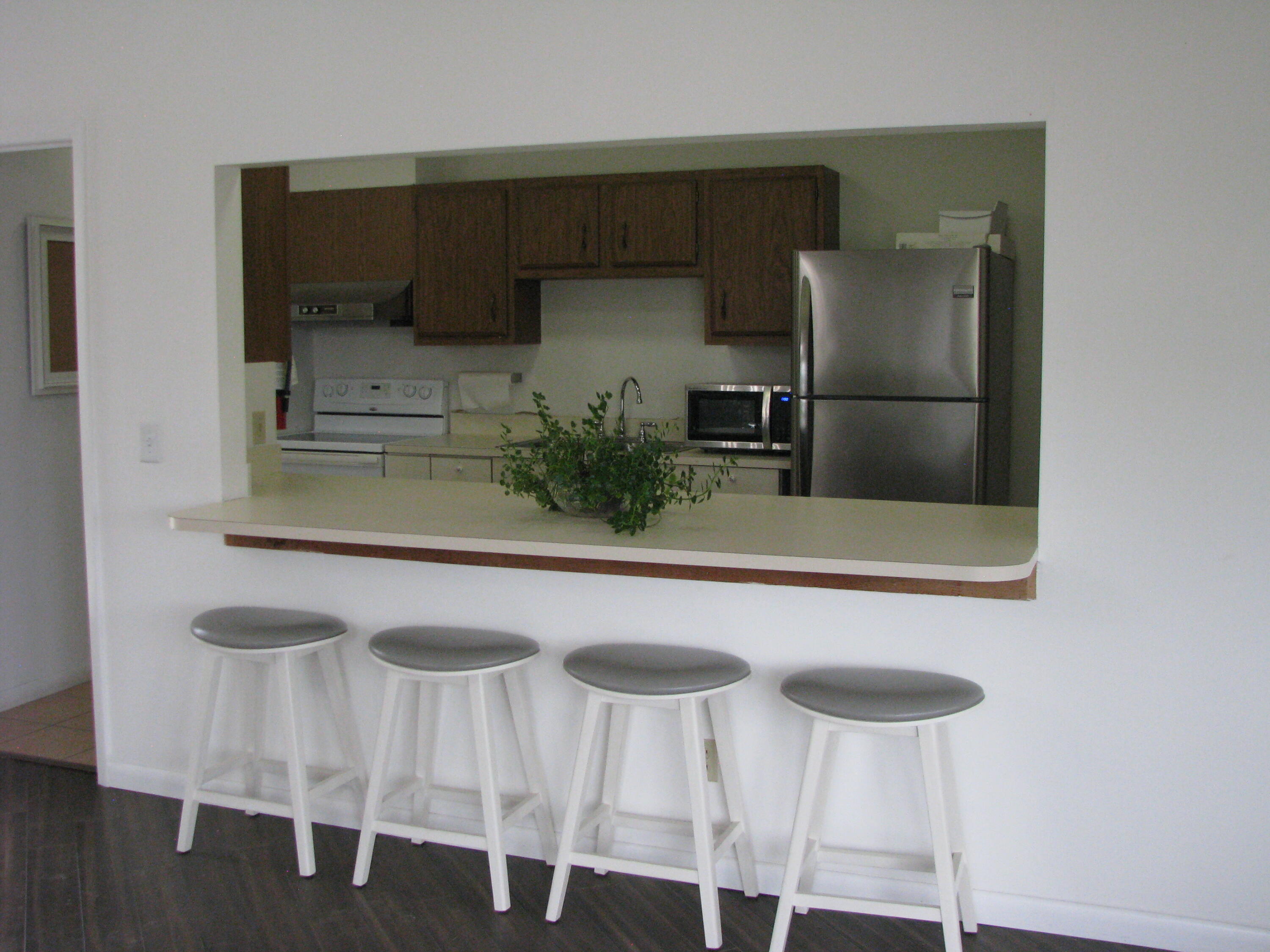 950 South Kanner Highway, Unit D4 Stuart, FL 34994 - Photo 32 of 36 a kitchen with stainless steel appliances a refrigerator and microwave