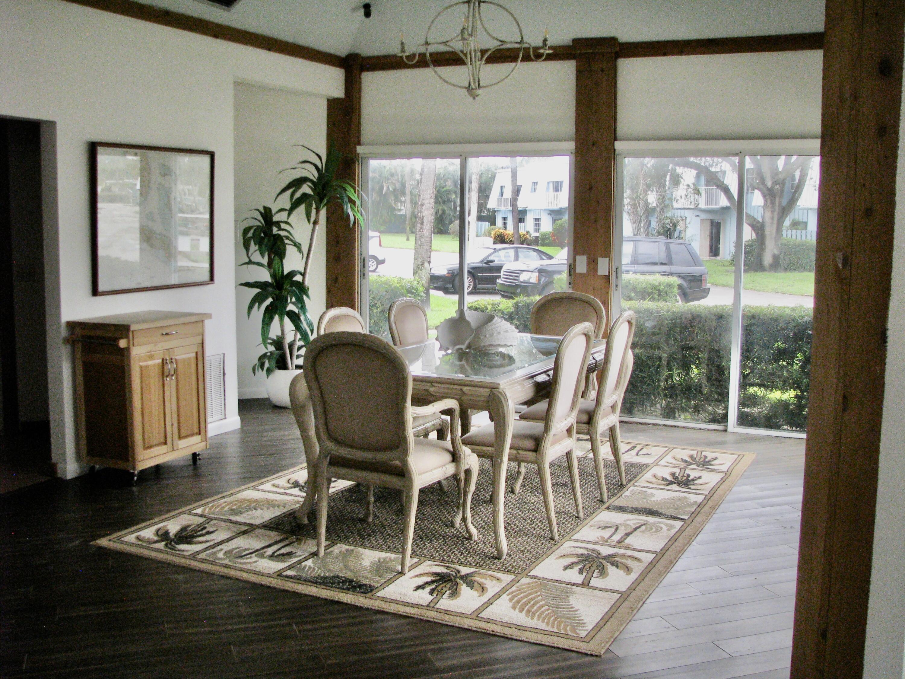 950 South Kanner Highway, Unit D4 Stuart, FL 34994 - Photo 35 of 36 a dining room with wooden floor a glass table and chairs