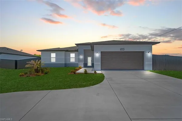 a front view of a house with a yard and garage