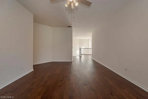 a view of a room with wooden floor and a ceiling fan