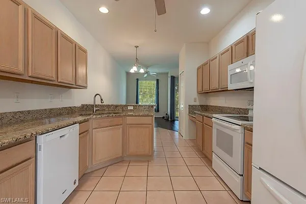 a kitchen with kitchen island granite countertop a stove sink and cabinets