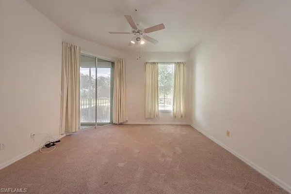 an empty room with closet and windows