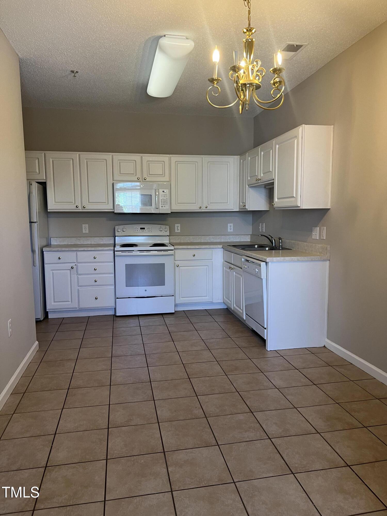 2501 Huntscroft Lane, Unit 200 Raleigh, NC 27617 - Photo 2 of 8 a kitchen with a sink cabinets and window