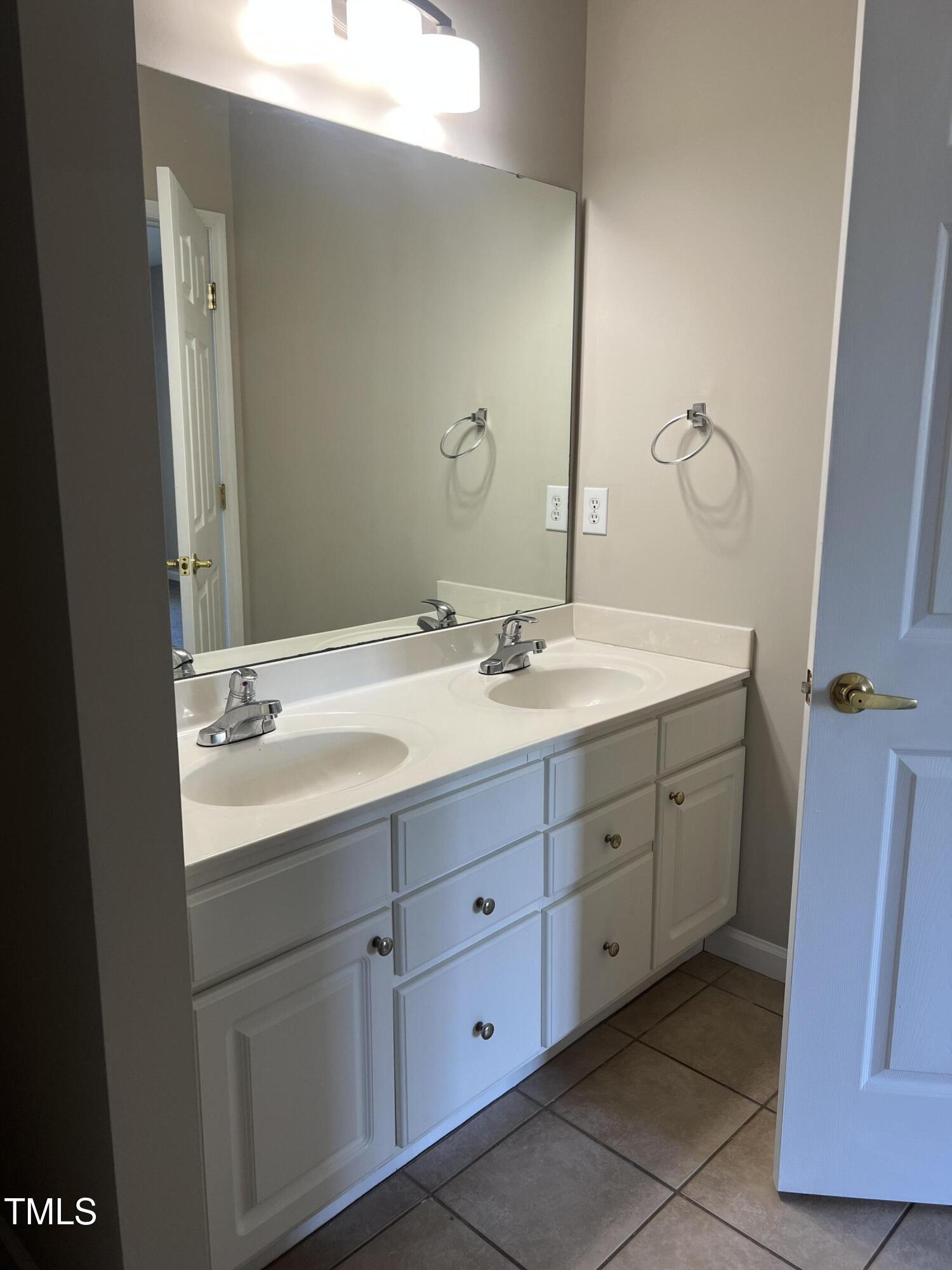 2501 Huntscroft Lane, Unit 200 Raleigh, NC 27617 - Photo 5 of 8 a bathroom with a double vanity sink and mirror