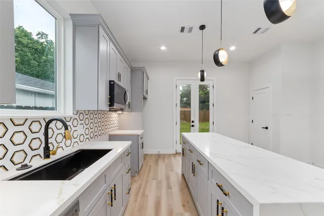 a spacious bathroom with a sink a large mirror and a bathtub