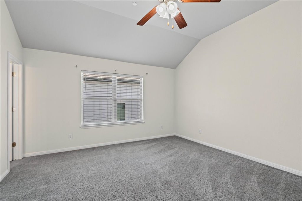 1502 Airedale Road, Unit 2502 Austin, TX 78748 - Photo 17 of 28 A spacious chamber, naturally illuminated, features a vaulted ceiling and soft gray carpeting.