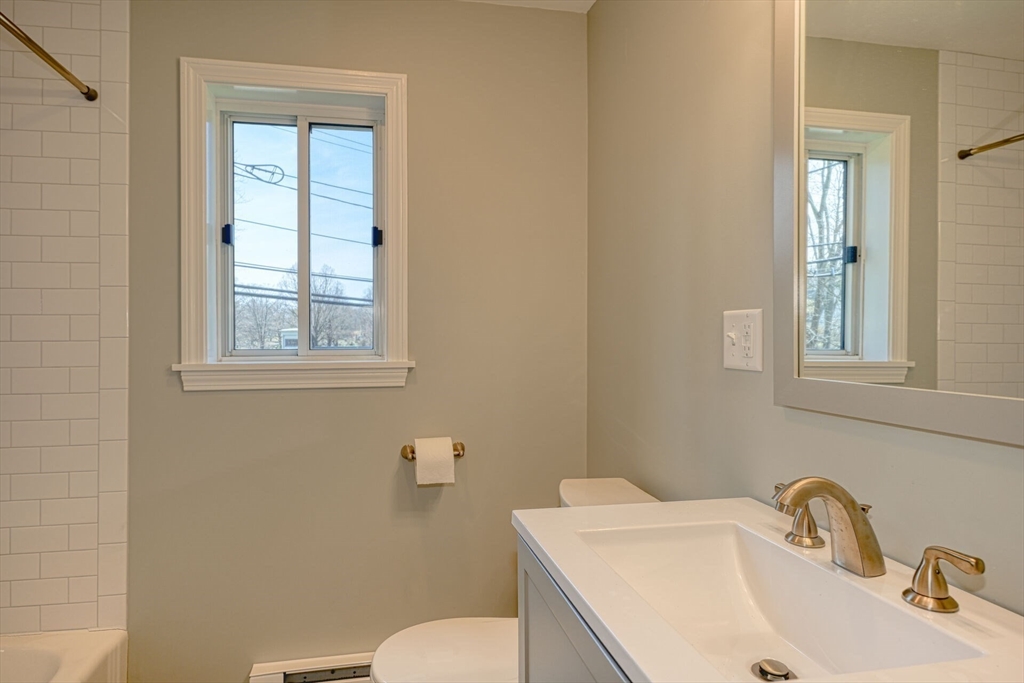 74 Beach Street, Unit 112 Woburn, MA 01801 - Photo 6 of 9 a bathroom with a sink a toilet and a window